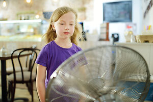 child with a pedestal fan